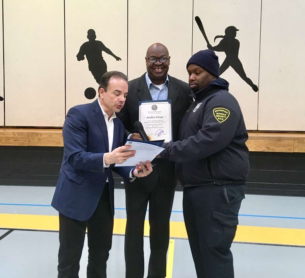 Inventor Andre Gray gets a certificate from Mayor Joe Ganim and Security Guard Harry Bell at Curiale School in Bridgeport. Feb. 11, 2019