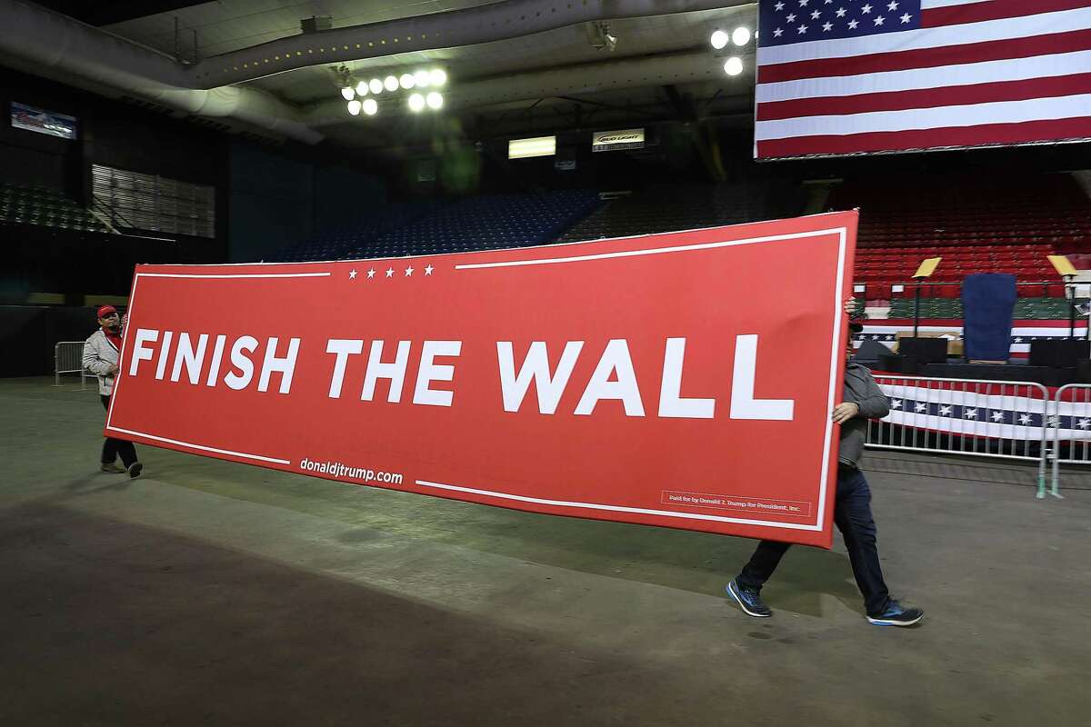 Workers carry a sign that reads 'Finish the Wall' as they prepare for the arrival of President Donald Trump for a rally at the El Paso County Coliseum on Monday, Feb. 11, 2019, in El Paso. Trump is expected to ask Congress to allocate funds for more wall to be built along the U.S./Mexico border as the Democrats in Congress ask for money for other border security measures. (Photo by Joe Raedle/Getty Images)
