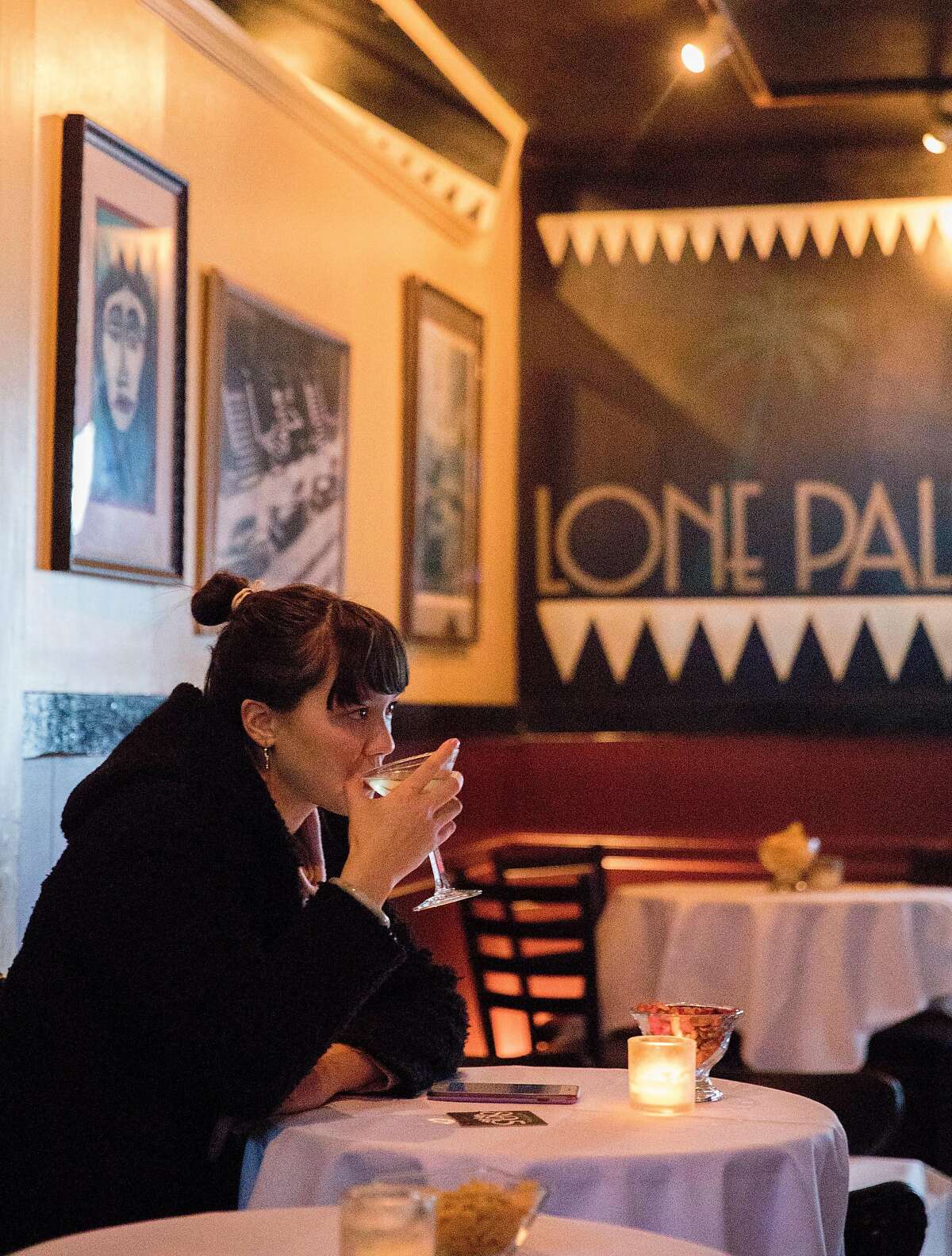 Kellsie Fong-Morro sips a martini while sitting at a white cloth table at Lone Palm in San Francisco, Calif. Saturday, Jan. 12, 2019.