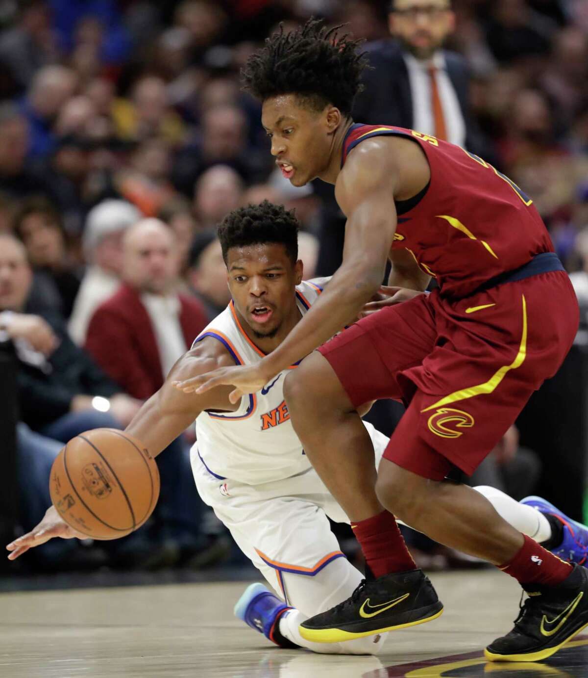 New York Knicks' Dennis Smith Jr., left, and Cleveland Cavaliers' Collin Sexton battle for a loose ball in the second half of an NBA basketball game, Monday, Feb. 11, 2019, in Cleveland. The Cavaliers won 107-104. (AP Photo/Tony Dejak)