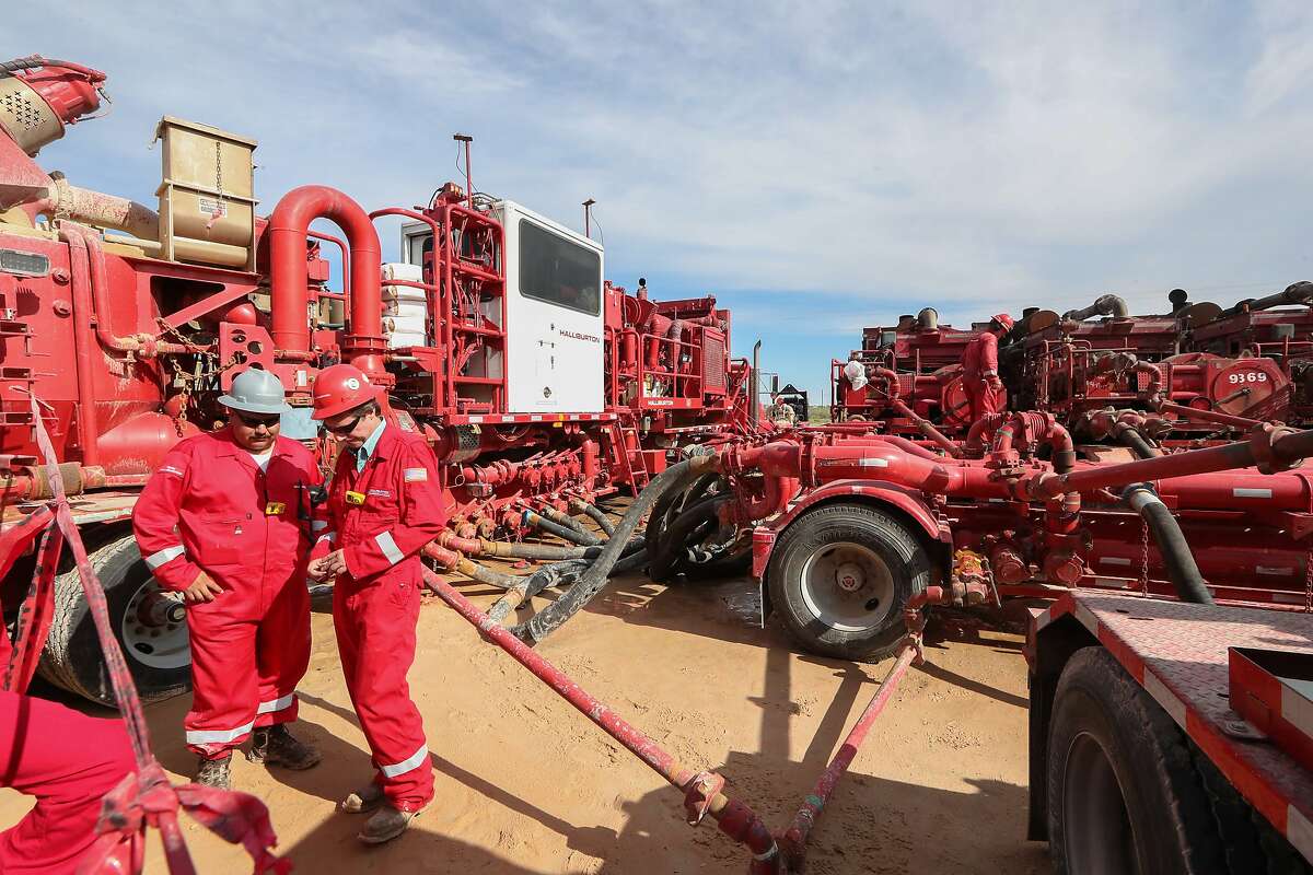 Halliburton employees work near rows of hydraulic fracturing pumping units at a three pad site Monday, June 26, 2017, in Midland. CONTINUE to see recent earnings from area energy companies. 