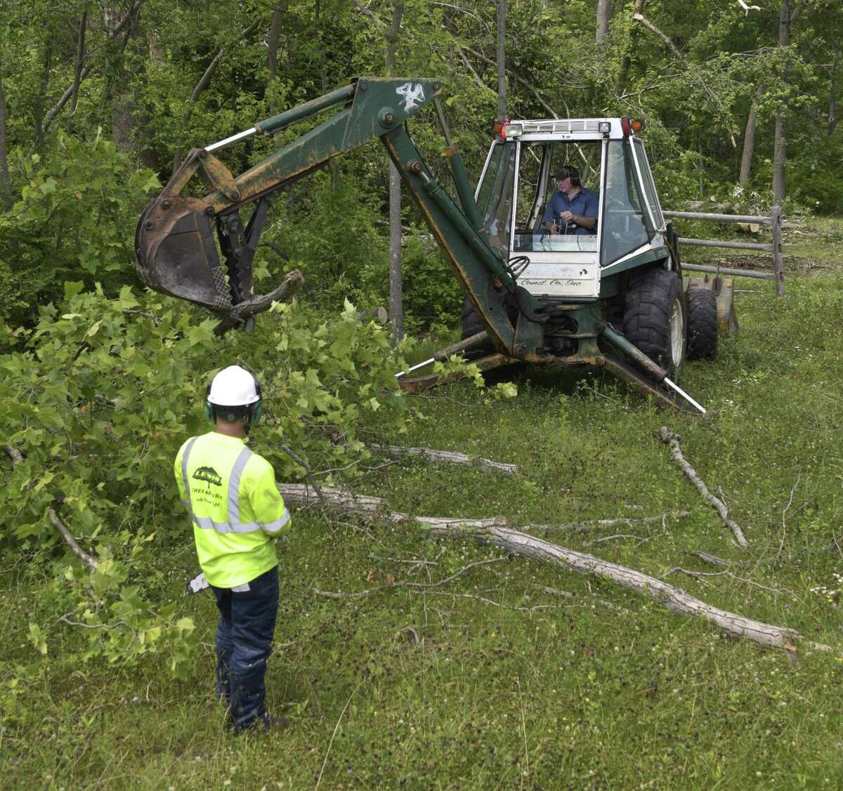 Silman Pinedo, left, and Bud Wright work on cleaning up the Still River Greenway. The trail had been closed since the May 15 storm that injured two people on the trail. Lewis Tree Service and Wright Tree Service donated their time to clear the trail from the police station to downtown.