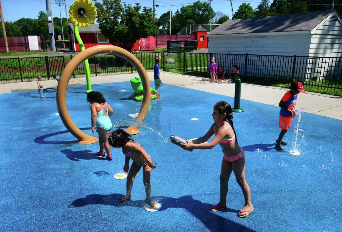 Jasmine Cabello, 8, of Stratford, throws water onto her little sister Nicole, 4, as they play at the spash pad at Longbrook Park in Stratford, Conn., on Tuesday July 10, 2018. The town is moving forward on putting another splash pad at Juliette Low Park.