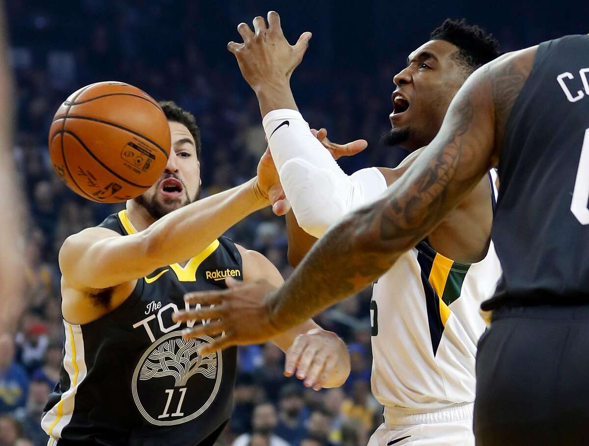 Golden State Warriors' Klay Thompson fouls Utah Jazz' Donovan Mitchell in 1st quarter during NBA game at Oracle Arena in Oakland, Calif., on Tuesday, February 12, 2019.