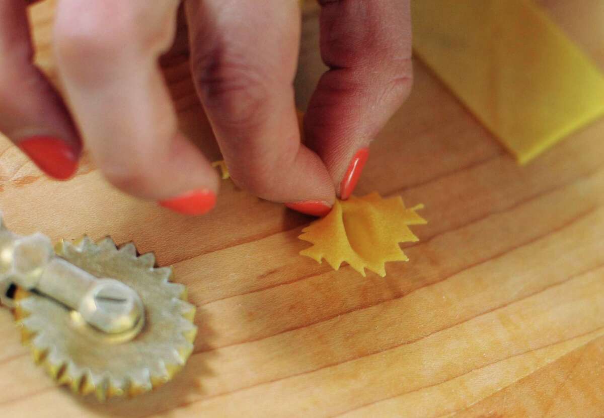 Elena D'Agostino pinches a rectangle of pasta into a farfalle, or bow tie, shape.