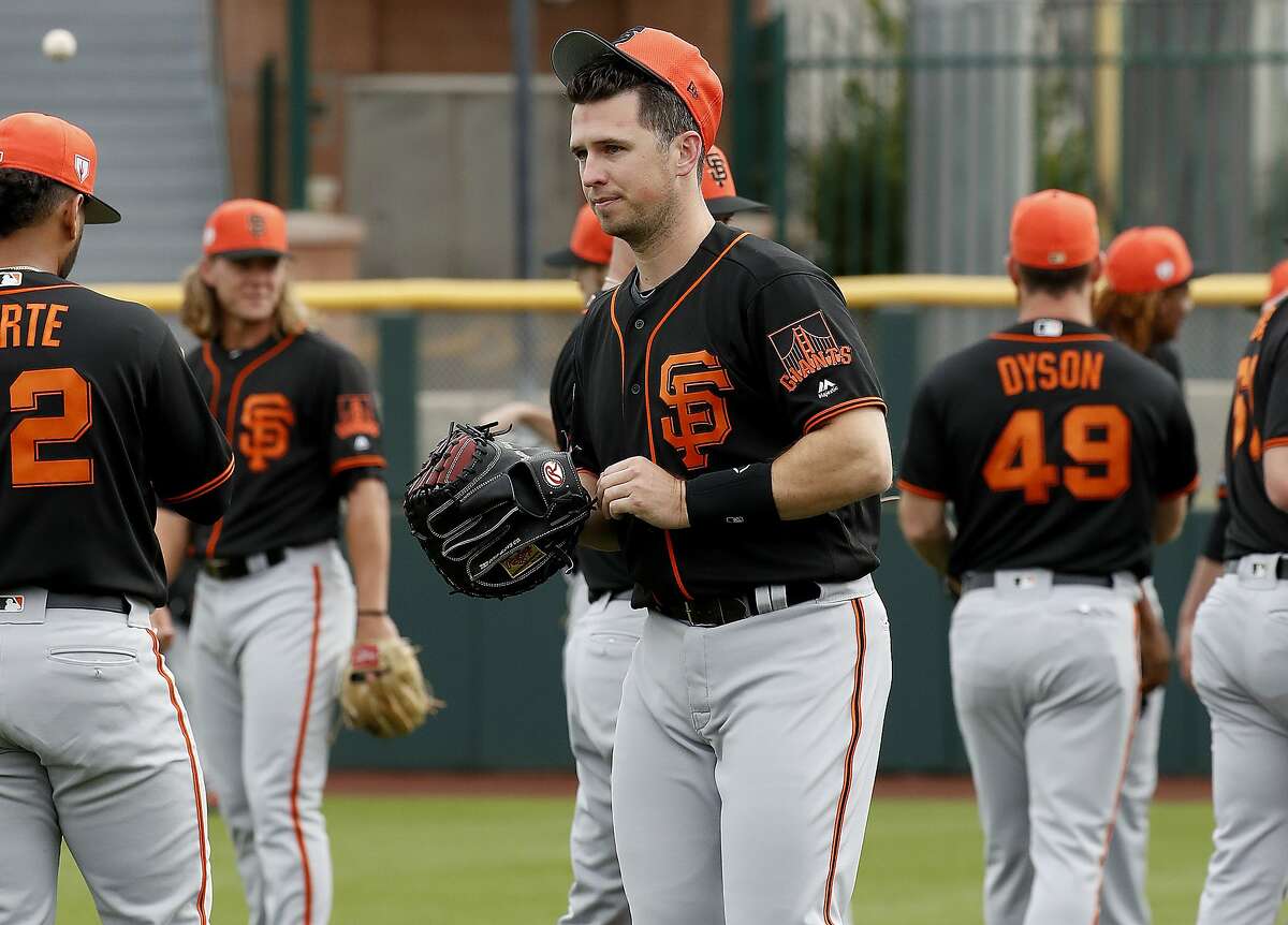 San Francisco Giants catcher Buster Posey takes the field during a baseball spring training practice, Wednesday, Feb. 13, 2019, in Scottsdale, Ariz. (AP Photo/Matt York)