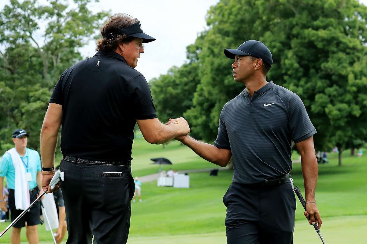 AKRON, OH - AUGUST 01: Phil Mickelson (L) and Tiger Woods meet during a preview day of the World Golf Championships - Bridgestone Invitational at Firestone Country Club South Course at on August 1, 2018 in Akron, Ohio. ~~