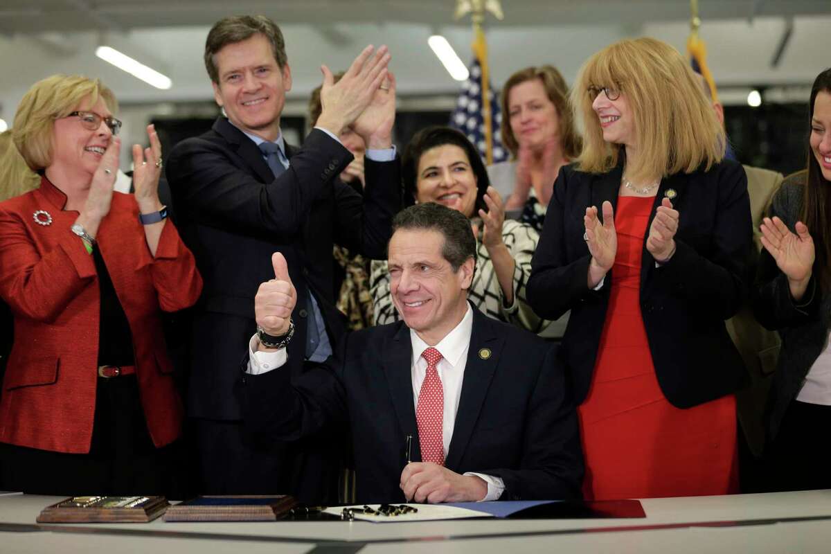 New York Gov. Andrew Cuomo, center, winks and gives a thumbs-up after signing the Child Victims Act in New York, Thursday, Feb. 14, 2019. Cuomo has signed into law long-sought legislation that extends the statute of limitations so sexual abuse victims can have more time to seek criminal charges or file lawsuits.