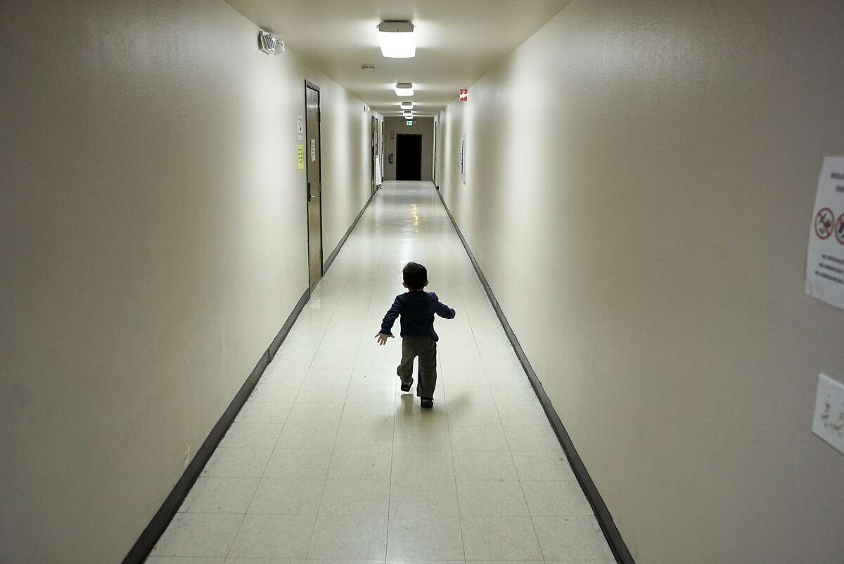 FILE - In this Dec. 11, 2018 file photo, an asylum-seeking boy from Central America runs down a hallway after arriving from an immigration detention center to a shelter in San Diego. The Trump administration says it would require extraordinary effort to reunite what may be thousands of migrant children who were separated from their parents and, even if it could, the children would likely be emotionally harmed. An official says removing children from "sponsor" homes to rejoin their parents "could be traumatic." (AP Photo/Gregory Bull, File)