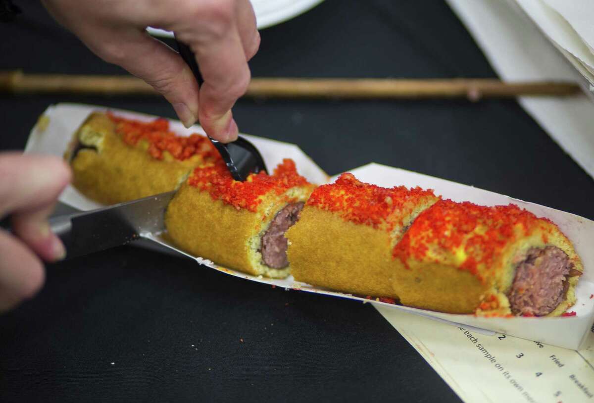 A foot-long corn dog covered in Flamin' Hot Cheetos is an example of the sumptuous carnival food you can expect at the Houston Livestock Show and Rodeo.