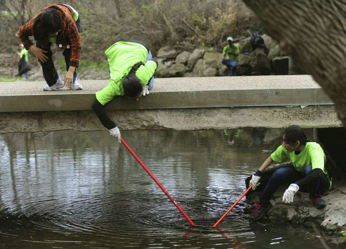 Incarnate Word Sister Leticia Rodriguez, left, and Rafia and Rukhfar Banu clean the San Antonio River headwaters during the Basura Bash annual cleanup on Feb. 26, 2011. The event this year will be Saturday.