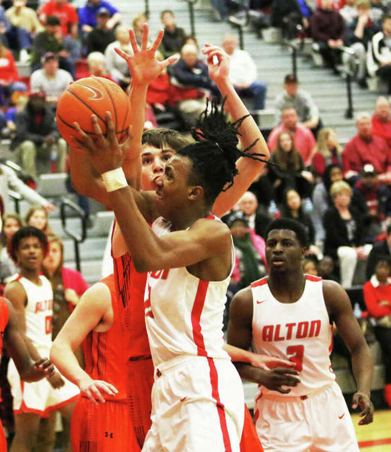 Alton’s Donovan Clay shoots over an Edwardsville defender during a Redbirds’ SWC victory last month at Alton High in Godfrey. The teams met again Thursday in Edwardsville with the Redbirds winning again at Lucco-Jackson Gym. Photo: Greg Shashack / The Telegraph