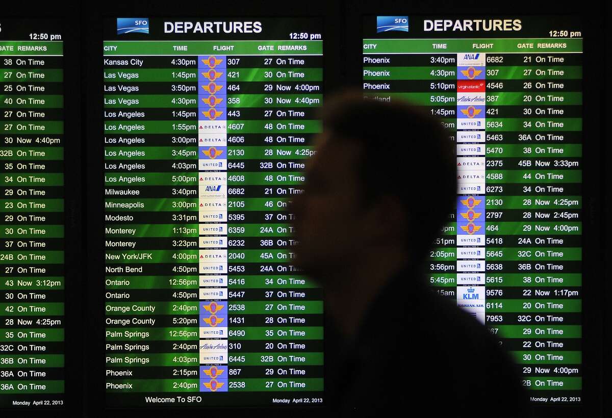 An unidentified traveler passes by a display of flights at San Francisco International Airport on April 22, 2013, in San Francisco. Federal budget cuts resulted in heavy delays for flights coming from the East Coast.