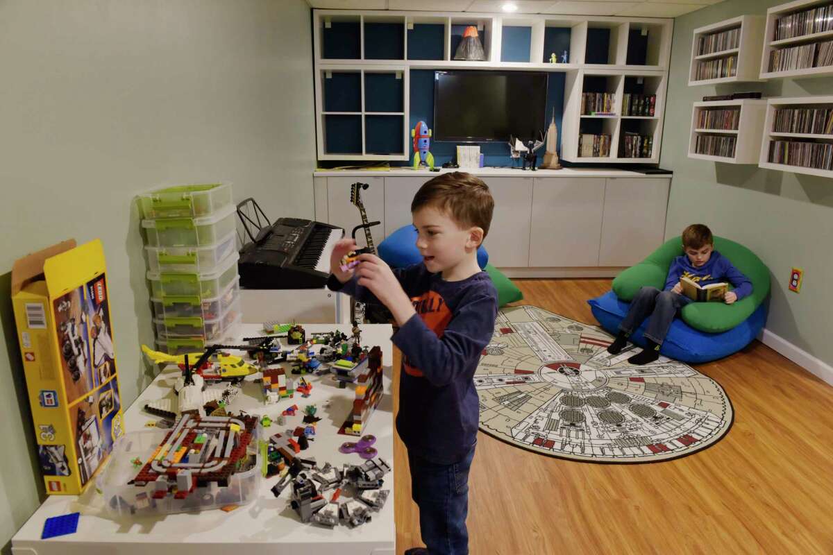 Devlin Trombley, 6, left, builds with Legos as his brother Rushton Trombley, 9, reads a book in the finished basement at their home on Tuesday, Feb. 12, 2019, in Gansevoort, N.Y. (Paul Buckowski/Times Union)