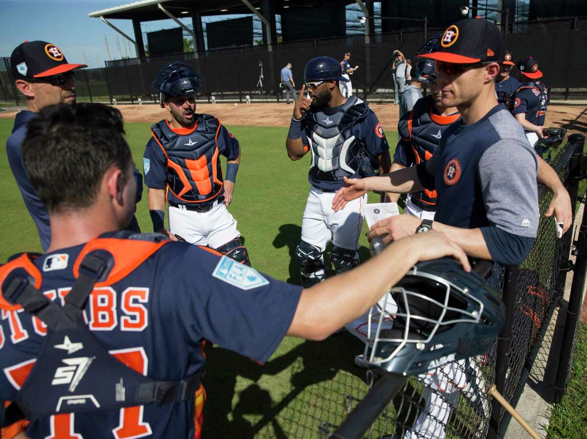 Houston Astros catchers Garrett Stubbs, from left, Lorenzo Quintana, Chuckie Robinson and Jamie Ritchie talk to minor league catching coordinator Mark Bailey, left, and catching coach Michael Collins during practice at Fitteam Ballpark of The Palm Beaches on Day 2 of spring training on Friday, Feb. 15, 2019, in West Palm Beach.