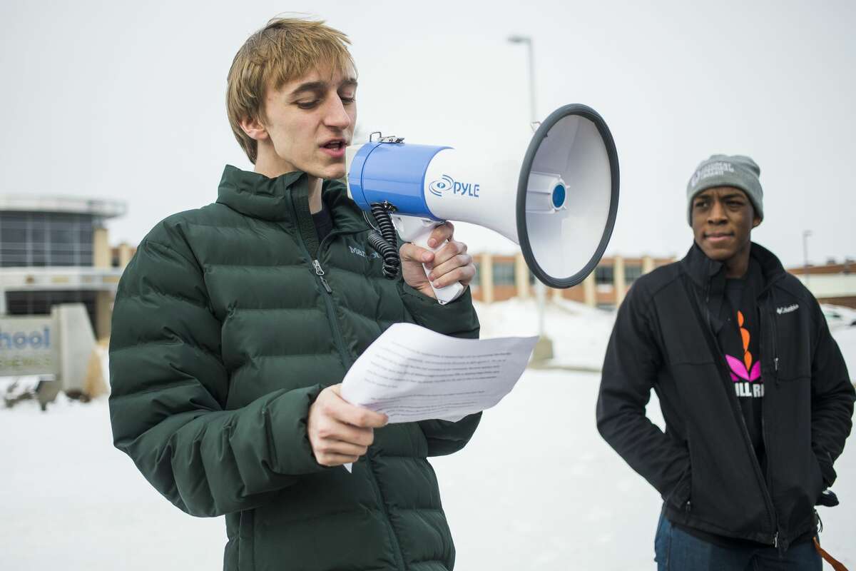 Midland High senior Jonathan Schulz, left, addresses a large crowd during a One Billion Rising event in support of women across the globe who suffer domestic abuse on Friday, Feb. 15, 2019 at Midland High School. (Katy Kildee/kkildee@mdn.net)