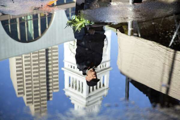 A Man Is Reflected In A Puddle At The Ferry Plaza Farmers Market In San Francisco A Man Is Reflected In A Puddle At The Ferry Plaza Farmers Market In San Francisco