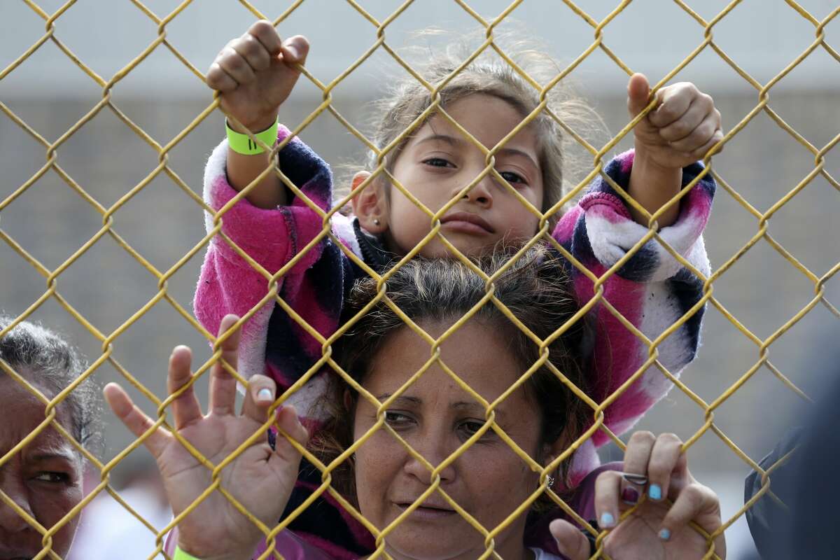 Six-year-old Daniela Fernanda Portillo Burgos, sits on the shoulders of her mother, Iris Jamilet, 39, as they look out through the fence of a immigrant shelter in Piedras Negras, Mexico, Tuesday, Feb. 5, 2019. The group numbering around 1,800 is at a state run shelter across the Rio Grande from Eagle Pass, Texas. The immigrants arrived on Monday and most are seeking asylum in the U.S. The family is from Honduras.