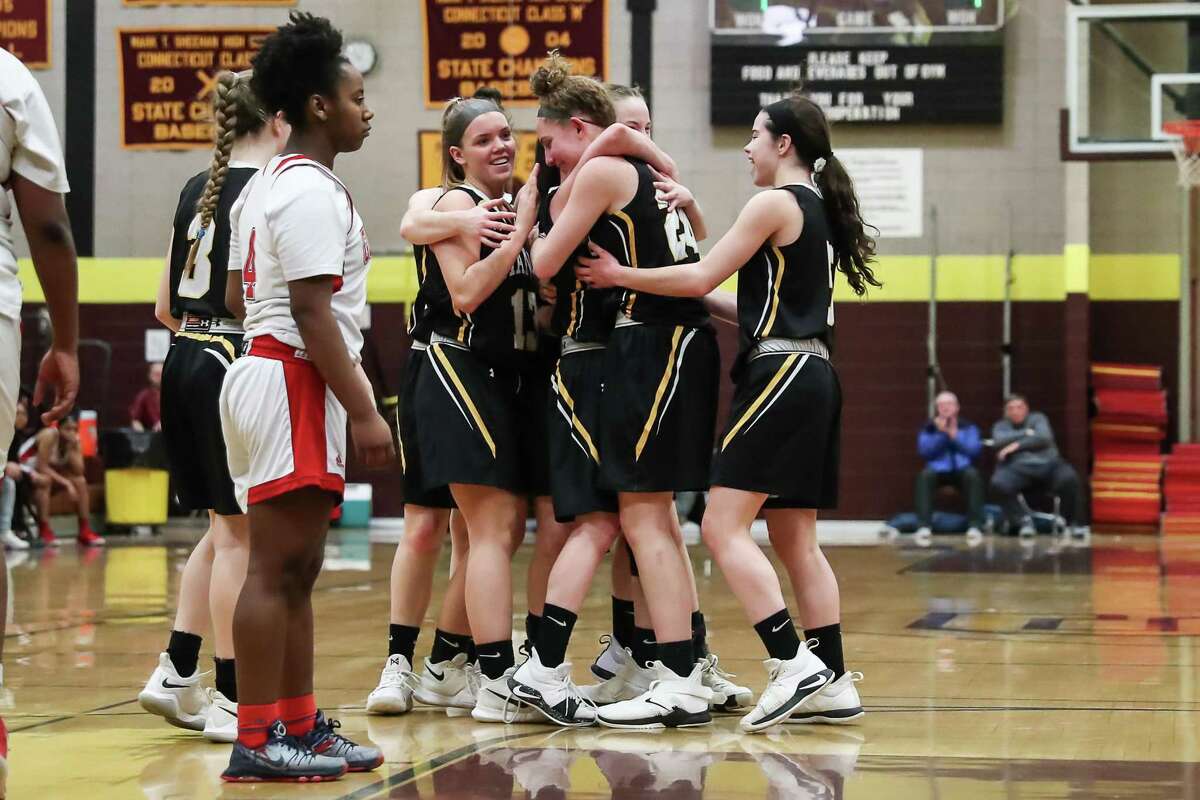 Hand players congratulate Sara Wohlgemuth after she recorded 1,000th career point during Saturday’s SCC quarterfinal against Wilbur Cross.