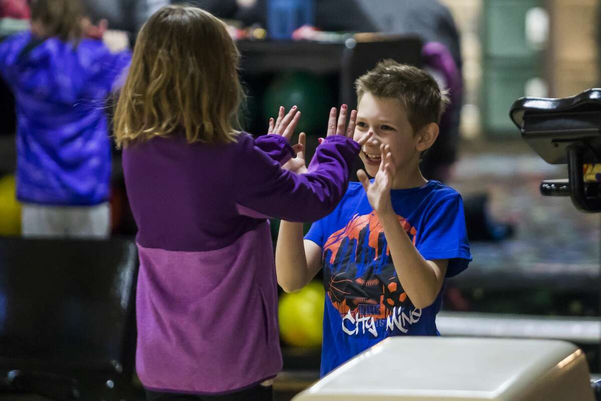Maddox Rowe, 8, right, high-fives Danielle Babcock, 7, left, during a youth bowling meet on Saturday, Feb. 16, 2019 at Northern Lanes in Sanford. (Katy Kildee/kkildee@mdn.net)