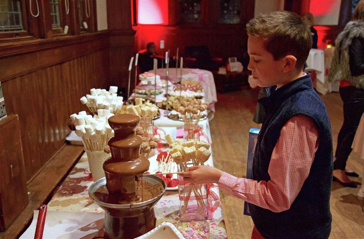 Hank Shantz, 12, of Fairfield, checks out the chocolate fountain at the Pequot Library's first-ever "Head over Heels" Valentine's Day party on Thursday, Feb. 14, 2019, in Fairfield, Conn.