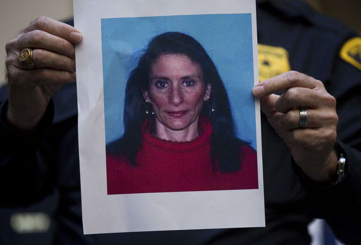 A Houston Police officer holds up the photo of one of the suspects, Rhogena Nicholas, during a news conference at Memorial Hermann Hospital on Tuesday, Jan. 29, 2019 in Houston. An attempt to serve a search warrant at a suspected drug house on Monday, quickly turned into a gunbattle that killed two suspects and injured five undercover narcotics officers, including four who were shot, Chief Art Acevedo said. Nicholas, was shot and killed as she tried to grab the service weapon of the first officer to be injured, Acevedo said. The second suspect killed was 59-year-old Dennis Tuttle. (Godofredo A. Vasquez/Houston Chronicle via AP)