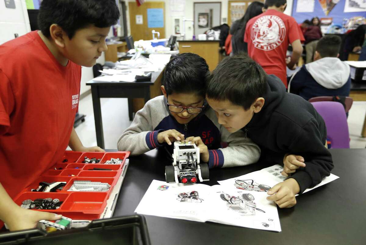 Alessandro Hidalgo, center, works with his teammates Lemuel Pacheco, left, and Alexander Molina as they built a Lego robot in engineering teacher, Jason Bradley's class at Stevenson Middle School in HISD where there are students focusing on STEM who are immigrants, Monday, Jan. 28, 2019, in Houston.