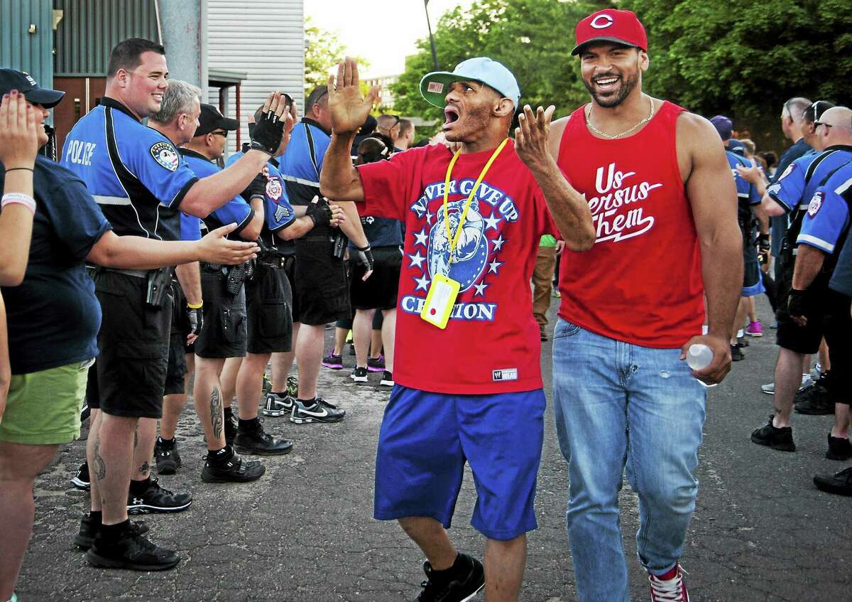 Then Cheshire police officer Jay Bodell, left, turns toward Earl Davis, center and Joel Garcia, right, as they are welcomed into the stadium at Southern Connecticut State University in New Haven. Police from across the state set up a receiving line for athletes and supporters arriving for the Special Olympics opening ceremonies in this archive photograph.