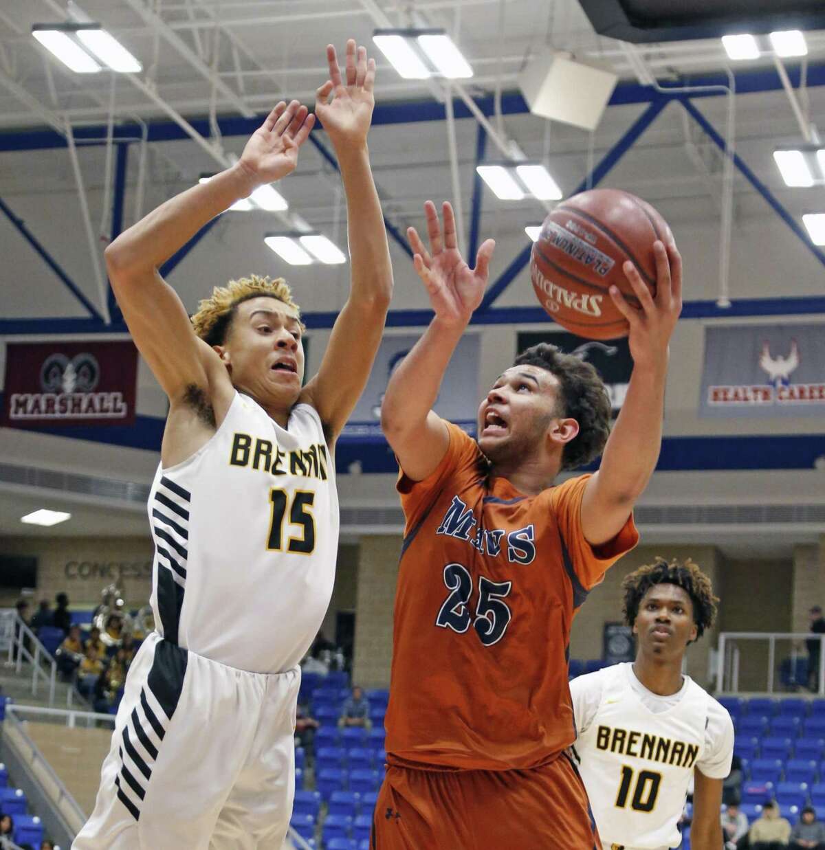 Madison's Keilon Johnson shoots over Brennan's Kyle Castille from the UIL Class 6A bidistrict high school boys basketball contest between Brennan and Madison at Northside ISD Gym.on Monday, February 19, 2019.