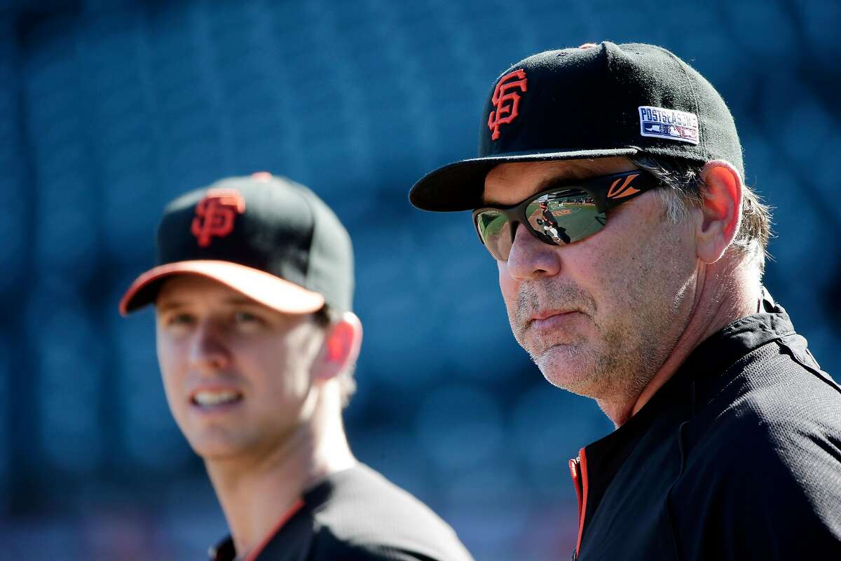 San Francisco Giants manager Bruce Bochy, right, watches batting practice alongside Buster Posey, at left, during a team workout on Saturday, Oct. 18, 2014, in San Francisco. The Giants are scheduled to play the Kansas City Royals in Game 1 of baseball's World Series on Tuesday, Oct. 21, in Kansas City. (AP Photo/Marcio Jose Sanchez)