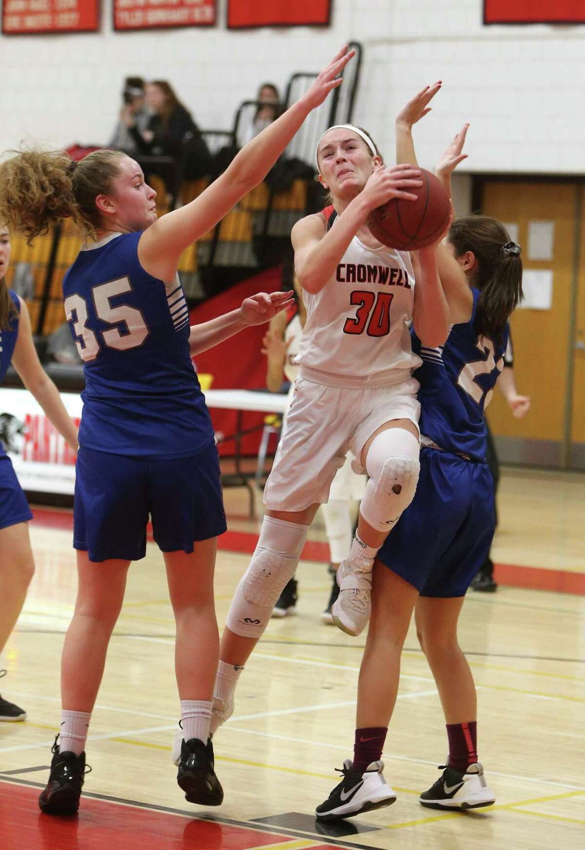 Cromwell High School’s Vanessa Stolstajner goes up for a shot over Old Lyme High School’s Emma McCulloch and Catherine Battalino during the girls varsity basketball game in Cromwell on Tuesday, Feb. 19.