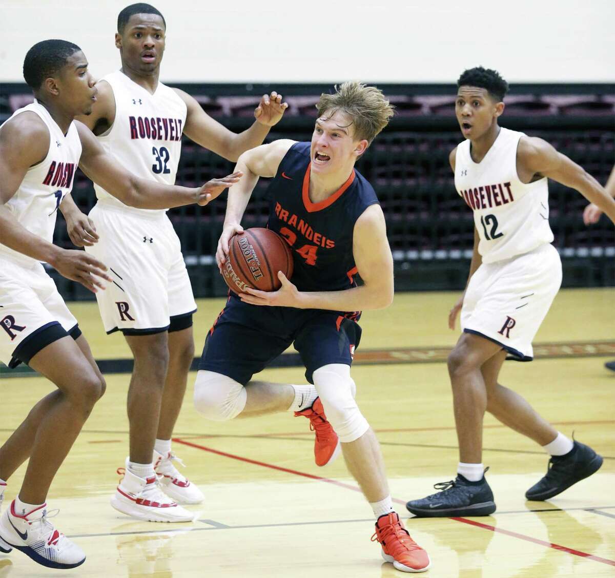 Kyle Schraeder splits a trio of defnders and gets to the lane for the Broncos as Roosevelt plays Brandeis in boys high school basketball playoffs at Littleton Gym on February 19, 2019.