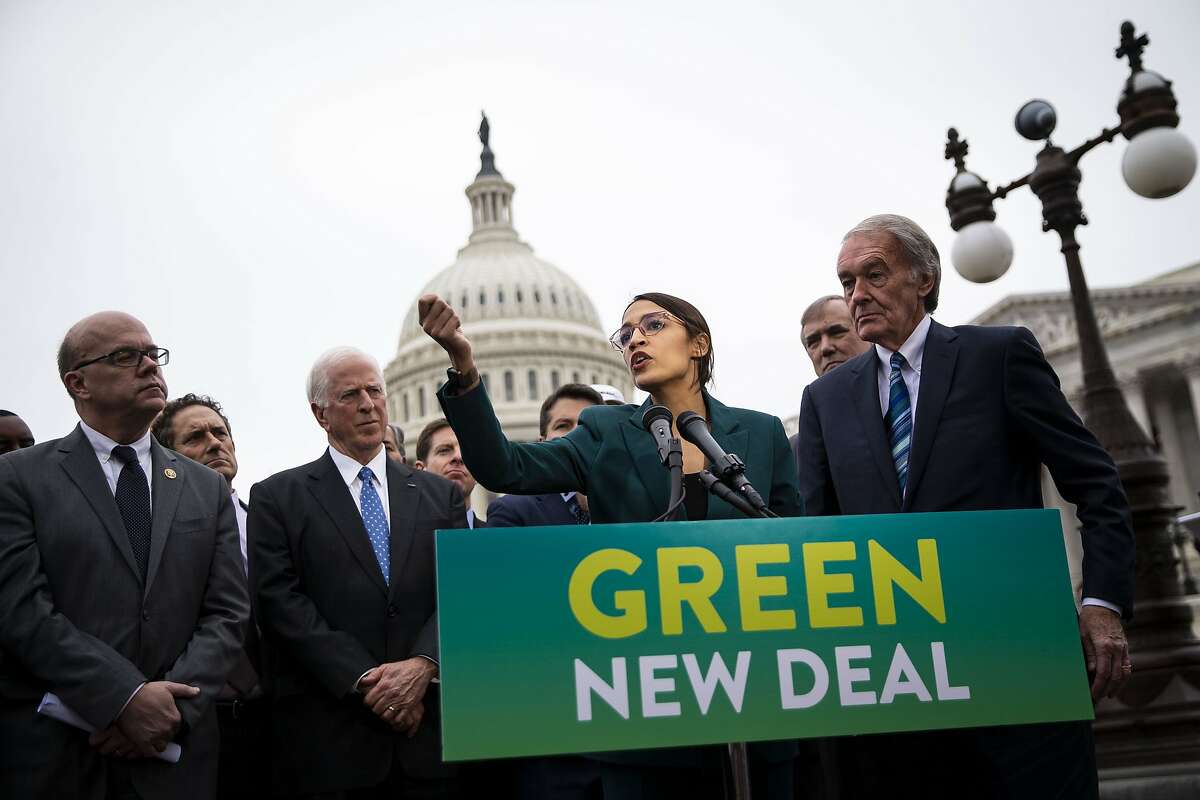 Representative Alexandria Ocasio-Cortez, a Democrat from New York, speaks as Senator Ed Markey, a Democrat from Massachusetts, right, listens during a news conference announcing Green New Deal legislation in Washington, D.C., U.S., on Thursday, Feb. 7, 2019. A sweeping package of climate-change measures unveiled Thursday by Ocasio-Cortez drew a tepid response from House Speaker Nancy Pelosi who didn't explicitly throw her support behind the measure. Hundreds of students from around the Bay Area are planning to walk out of school on Friday to demand urgent action on climate change. 