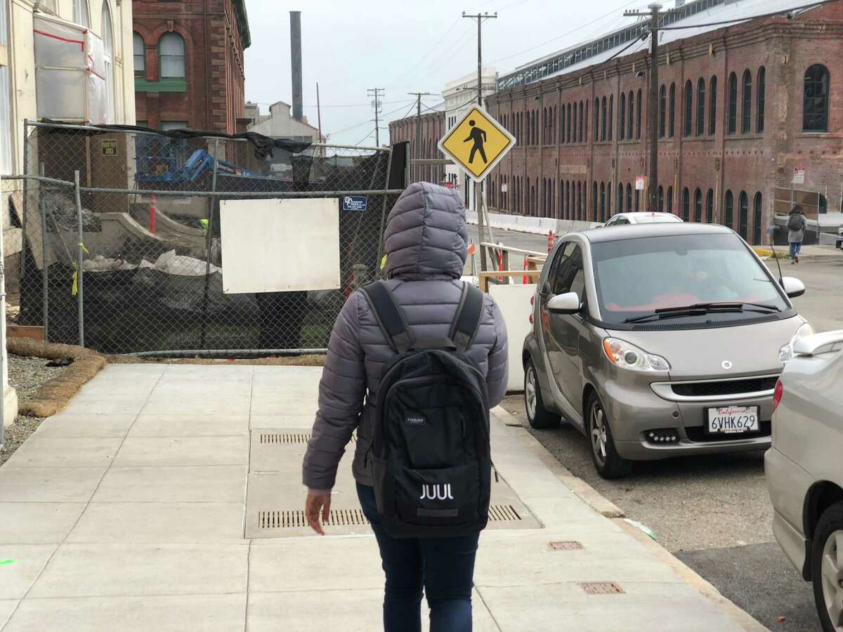 A person wearing a Juul backpack walks towards the e-cigarette maker’s headquarters on Pier 70 along the city’s waterfront on Dec. 20, 2018 in San Francisco, Calif.