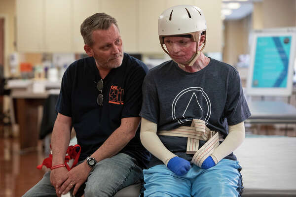 Karl Sutterfield talks with his son, Zachary Sutterfield, during a break in his physical therapy session at the U.S. Army Institute of Surgical Research Burn Center.