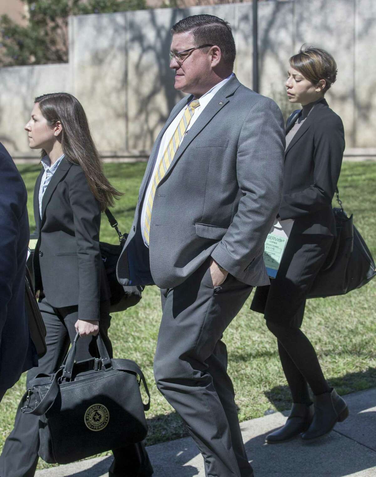 Keith Ingram, center, director of elections at the Texas Secretary of State's office, leaves the John H. Wood Federal Courthouse Tuesday, Feb. 20, 2019 after testifying during a hearing about the state?•s initiative to purge tens of thousands of Texans from voter rolls who officials claim are not U.S. citizens. The League of United Latin American Citizens has sued the state over the plan and is seeking an injunction to stop the plan.