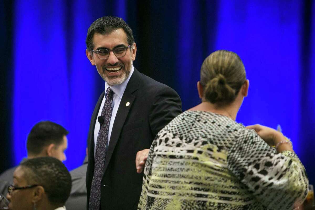 Newly appointed chancellor of the Alamo Colleges Mike Flores shares a laugh with an attendee before speaking at the Hispanic Chamber luncheon held at Embassy Suites at Brooks Oct. 10. The recent announcement of the “Alamo Promise” could be a game-changer for many Bexar County students.