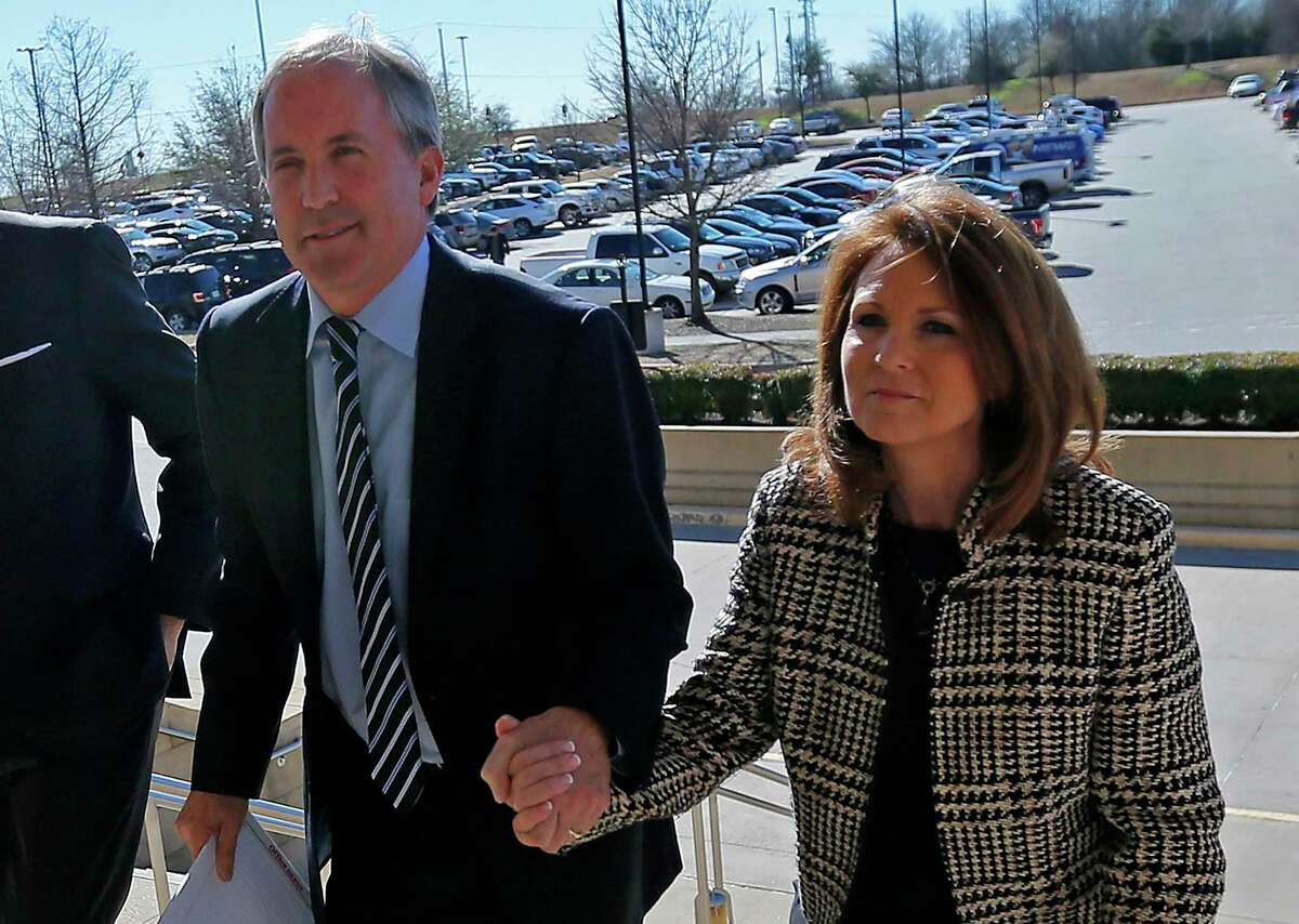 FILE - In this Feb. 16, 2017, file photo, Texas Attorney General Ken Paxton, left, arrives at the Collin County Courthouse with his wife Angela in McKinney, Texas. The wife of Texas Attorney General says a bill she filed that would change state securities law "literally has nothing to do" with her husband's criminal case on charges of defrauding investors. Republican state Sen. Angela Paxton, who was elected in November, said Tuesday, Feb. 19, 2019, that she didn't consult with her husband on the bill, which calls for the attorney general's office to create a framework that would let entrepreneurs test some financial products and services without a license. (Jae S. Lee/The Dallas Morning News via AP, File)