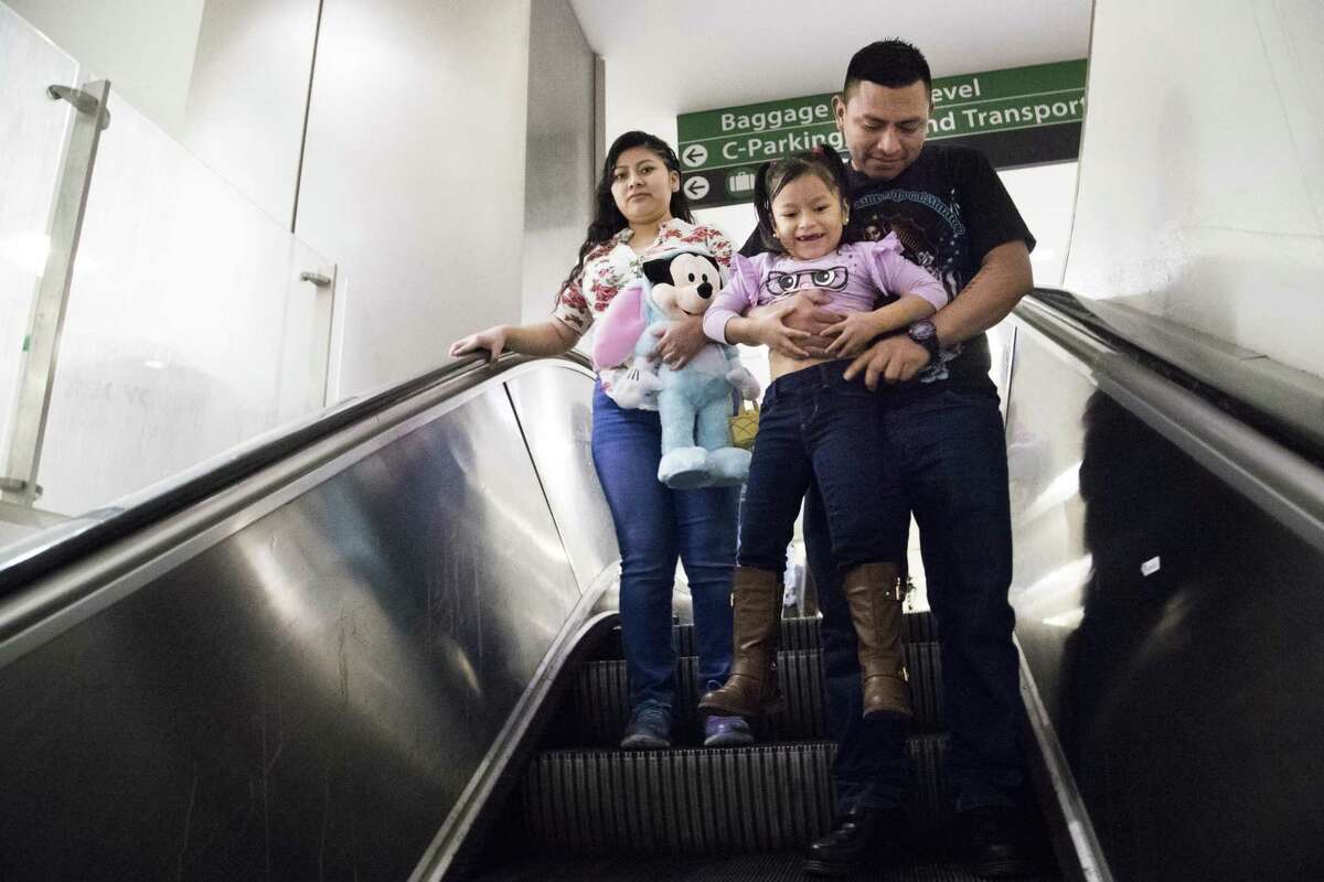 Alida, 5, and her mother Sara Caal exit a baggage claim area at George Bush International Airport on Thursday, Feb. 21, 2019, in Houston after finally seeing each other after being apart for nine months. The Guatemalan mother and daughter were separated after being detained at the Texas-Mexico border.