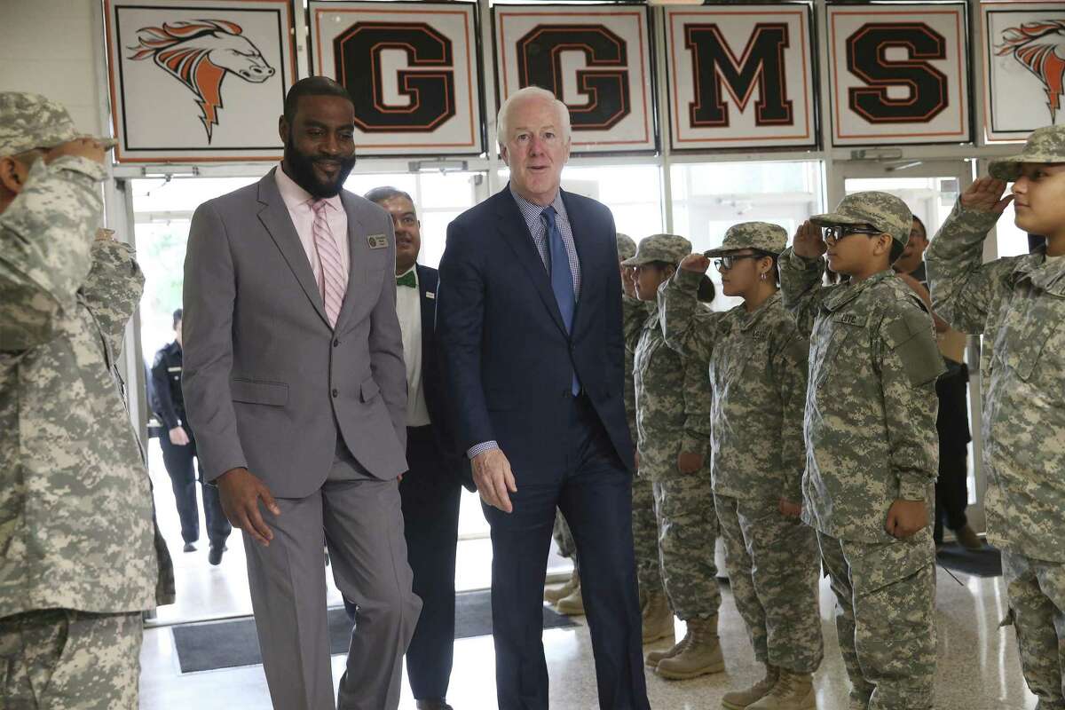 Members of the Leadership Officer Training Corps at Gus Garcia Middle School salute as U.S. Sen. John Cornyn, R-Texas (right) enters the school with Principal Christopher Bland (left) and Edgewood Superintendent Eduardo Hernández (back) for a meeting with school administrators from Edgewood, SAISD and Somerset along with students at Gus Garcia Middle School as they discuss the federal grant program, GEAR UP, and legislation to modernize it on Thursday, Feb. 21, 2019. GEAR UP is a college/career readiness grant that Edgewood, SAISD and Somerset uses to begin advising kids as early as middle school. (Kin Man Hui/San Antonio Express-News)