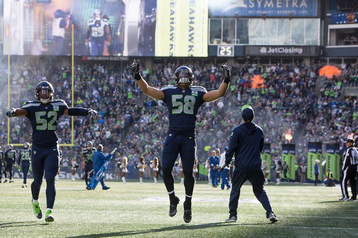 Seahawks linebacker Emmanuel Ellerbee (52) and linebacker Austin Calitro (58) hype up the crowd before the Seahawks game against the LA Chargers, Sunday, Nov. 4, 2018 at CenturyLink Field. (Genna Martin, seattlepi.com)