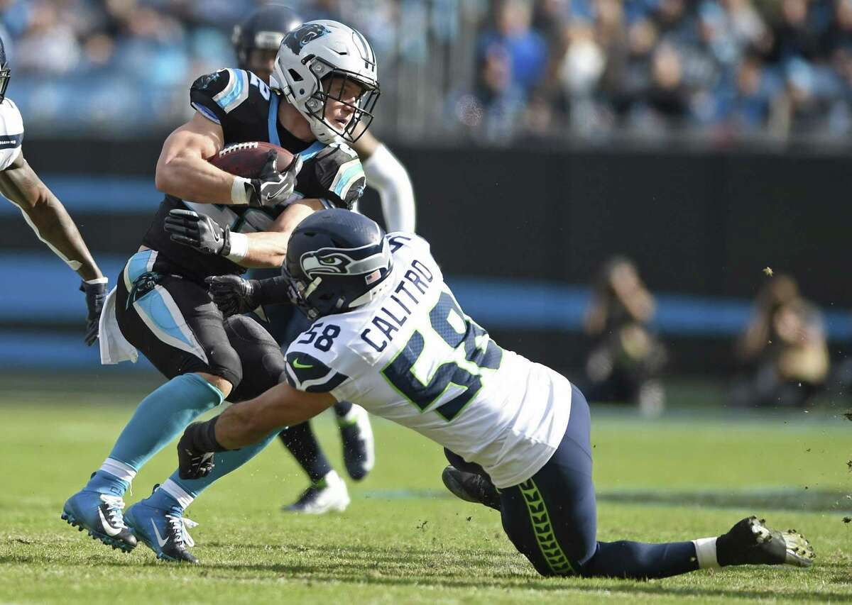 Carolina Panthers' Christian McCaffrey (22) is stopped by Seattle Seahawks' Austin Calitro (58) during the first half of an NFL football game in Charlotte, N.C., Sunday, Nov. 25, 2018. (AP Photo/Mike McCarn)