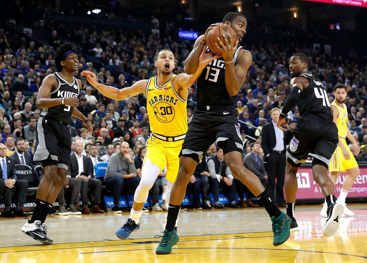 Golden State Warriors' Stephen Curry tries to steal the ball from Sacramento Kings' Alec Burks during NBA game at Oracle Arena in Oakland, Calif., on Thursday, February 21, 2019.