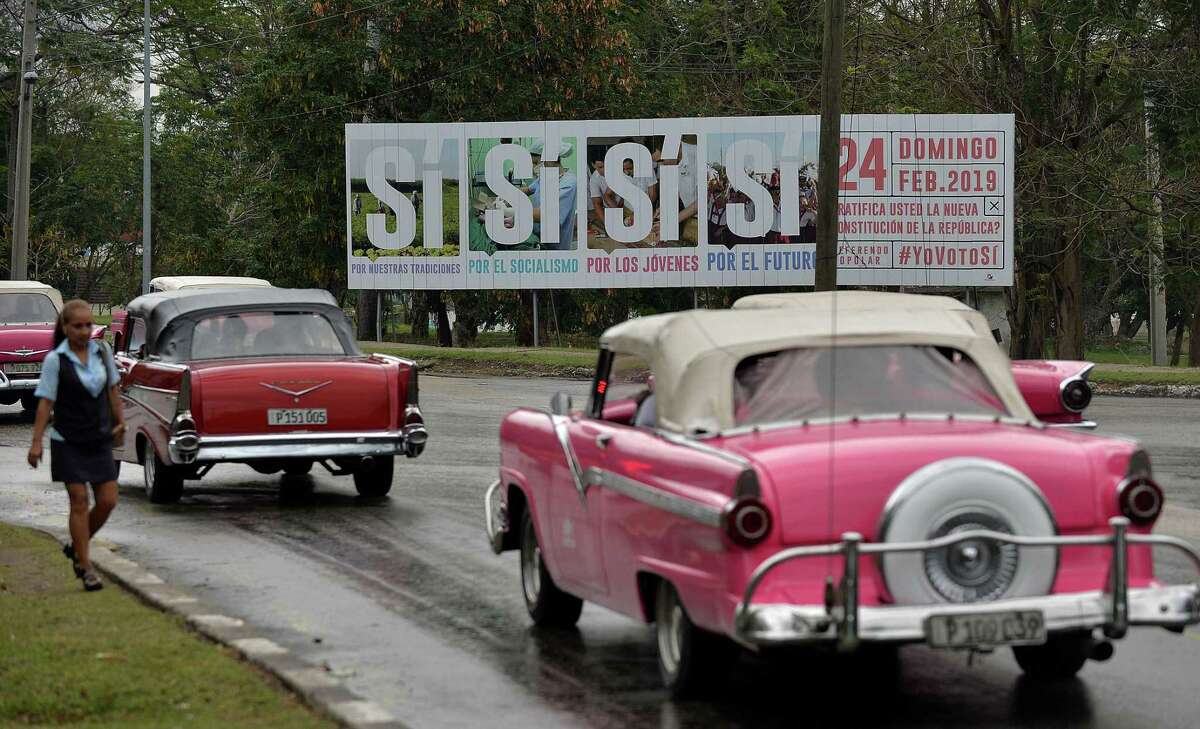 Old American cars drive near a government's campaign billboard encouraging to vote for the Constitution in Havana, on February 13, 2019. - On buses, in supermarkets or in television: in Cuba, the slogan of the socialist government #YoVotoSi (I vote yes) to the new Constitution, that will be submitted to a referendum on February 24, is omnipresent, sparking discontent in social networks. (Photo by YAMIL LAGE / AFP)YAMIL LAGE/AFP/Getty Images