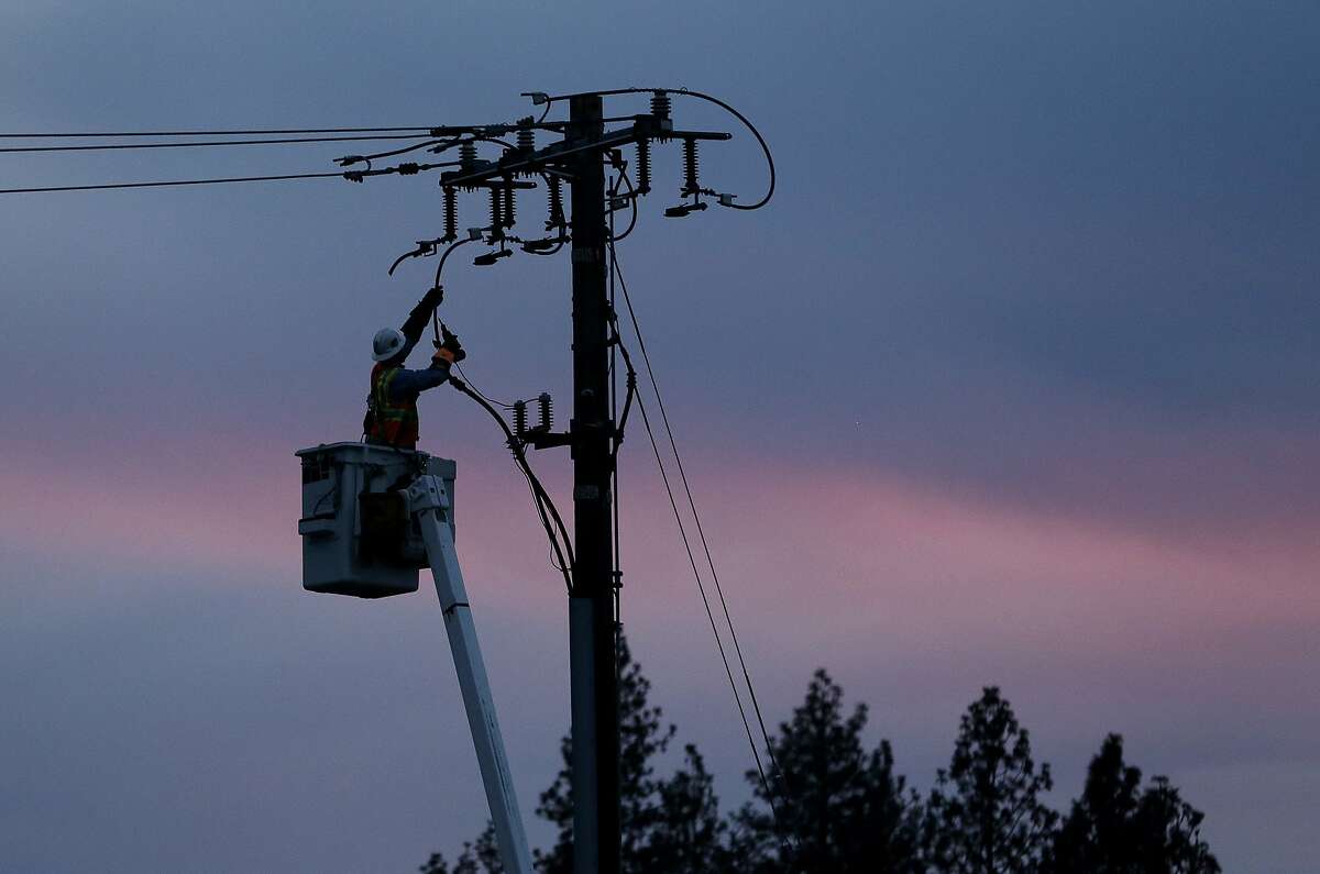 FILE - In this Nov. 26, 2018, file photo, a Pacific Gas & Electric lineman works to repair a power line in fire-ravaged Paradise, Calif. A U.S. judge who has berated Pacific Gas & Electric Co. for its role in wildfires in California is demanding more answers from the utility. In a court filing on Thursday, Feb. 14, 2019, Judge William Alsup asked PG&E whether it was in compliance with a state law that requires it to clear vegetation around electric lines. The judge also questioned a part of the utility's recently submitted wildfire mitigation plan. (AP Photo/Rich Pedroncelli, File)