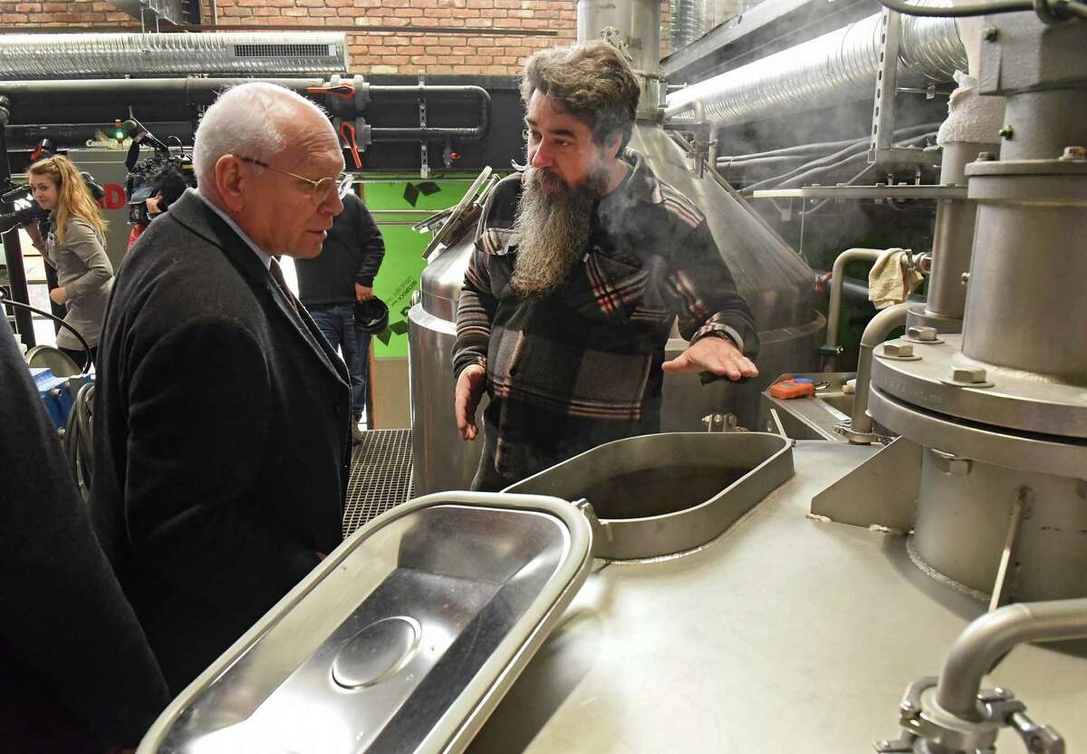 Master Brewer Rich Michaels, right, explains the beer making process to Congressman Paul Tonko as he takes a tour of the Frog Alley Brewing at the Mill Artisan District construction project on Friday, Feb. 22, 2019 in Schenectady, N.Y. (Lori Van Buren/Times Union)