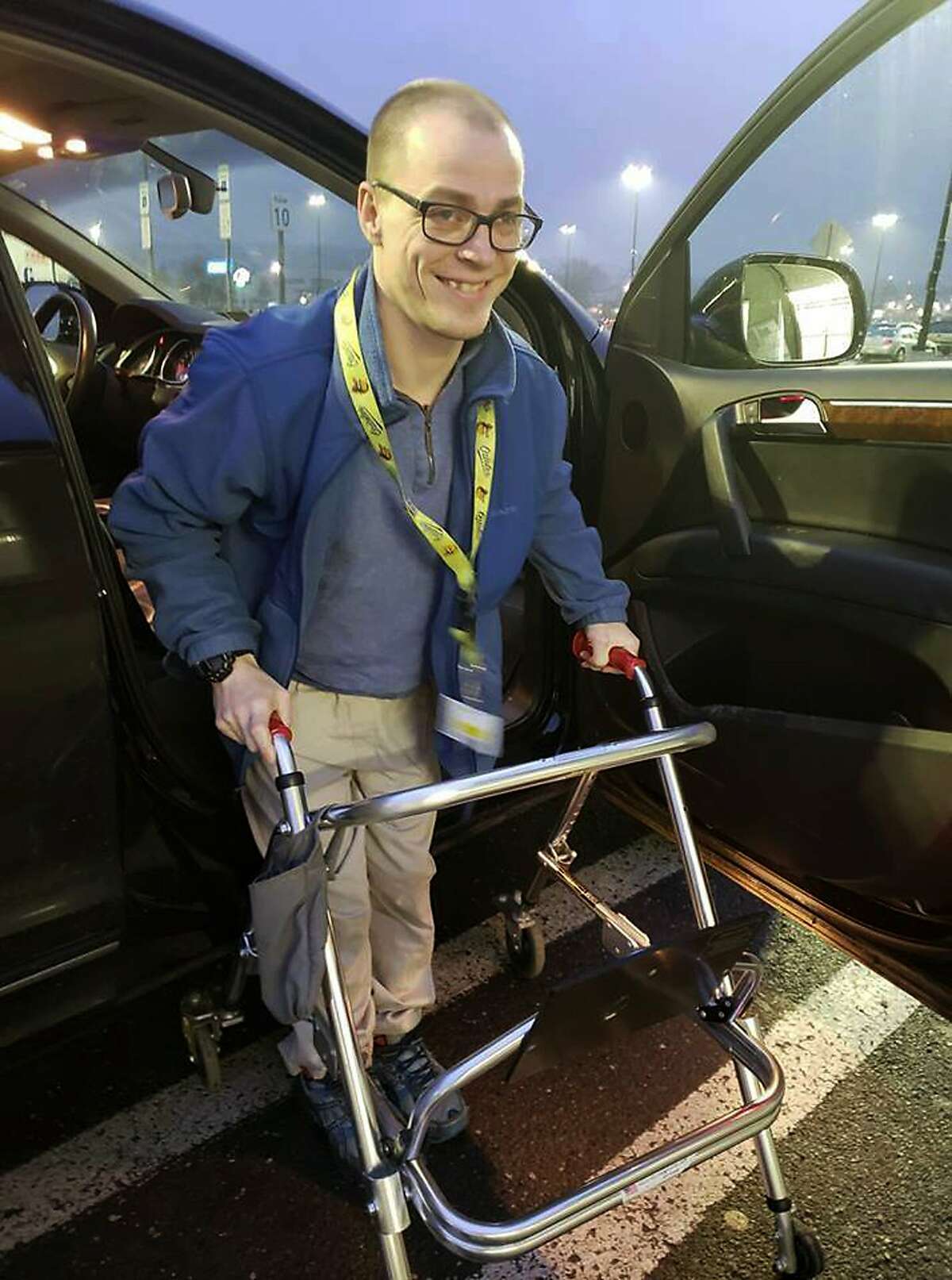 In this Dec. 14, 2018 photo provided by Holly Catlin, Adam Catlin gets out of a car before starting his shift at a Walmart in Selinsgrove, Pa. Catlin, who has cerebral palsy, is afraid he’ll be out of work after store officials changed his job description to add tasks that he’s physically unable to do. (Holly Catlin via AP)