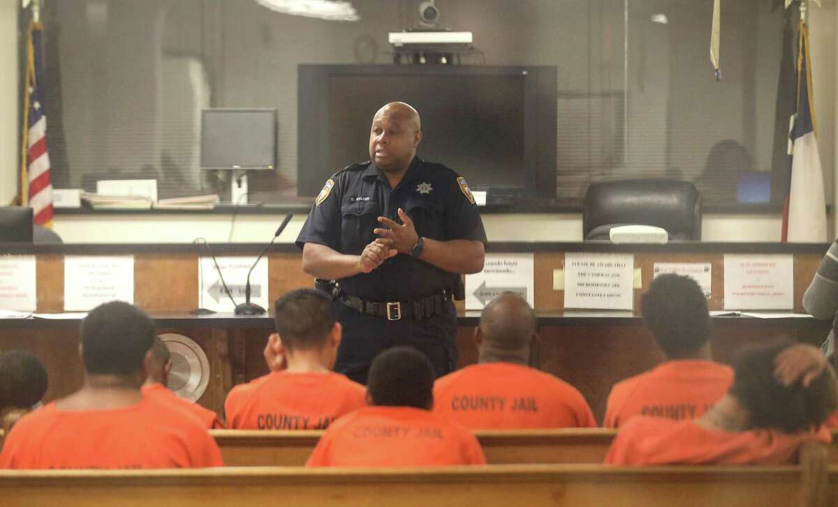 Harris County Sheriff’s Deputy D. Walker speaks to defendants before a probable cause hearing in Houston. Bail reform is breaking ground in Harris County.