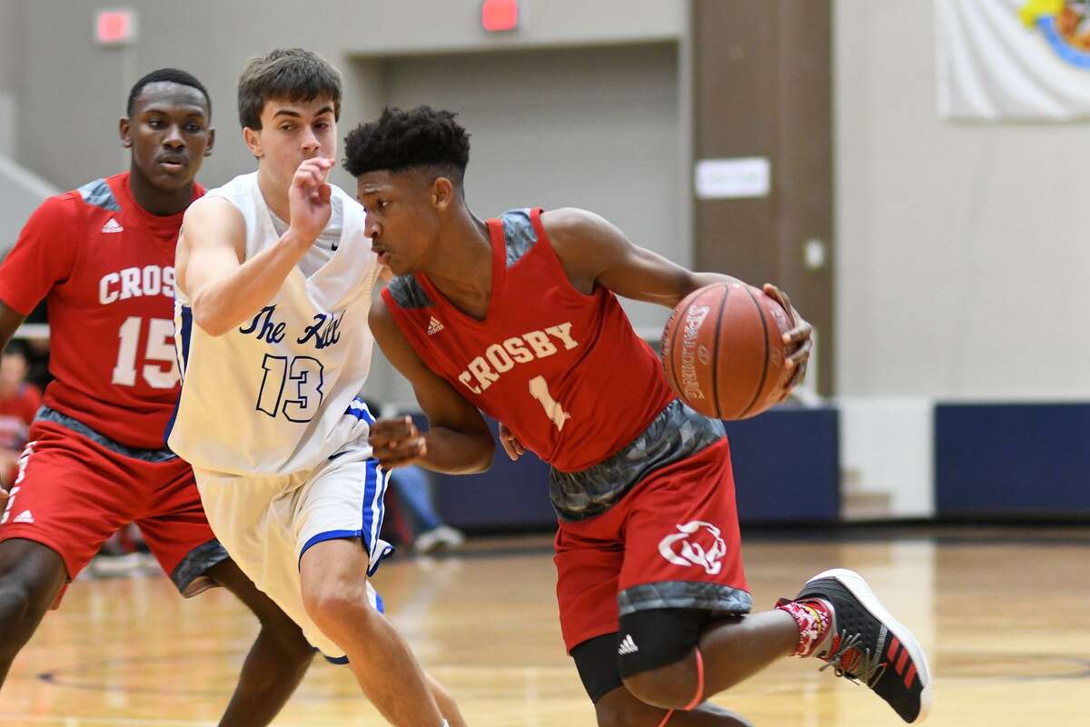 Crosby sophomore guard Kaleb Stewart (1) drives to the hoop against Barbers Hill junior guard Mason Daniels (13) in the 1st quarter of their Region III-5A Bi-District Playoff matchup at Phillips Fieldhouse in Pasadena on Feb. 19, 2019.