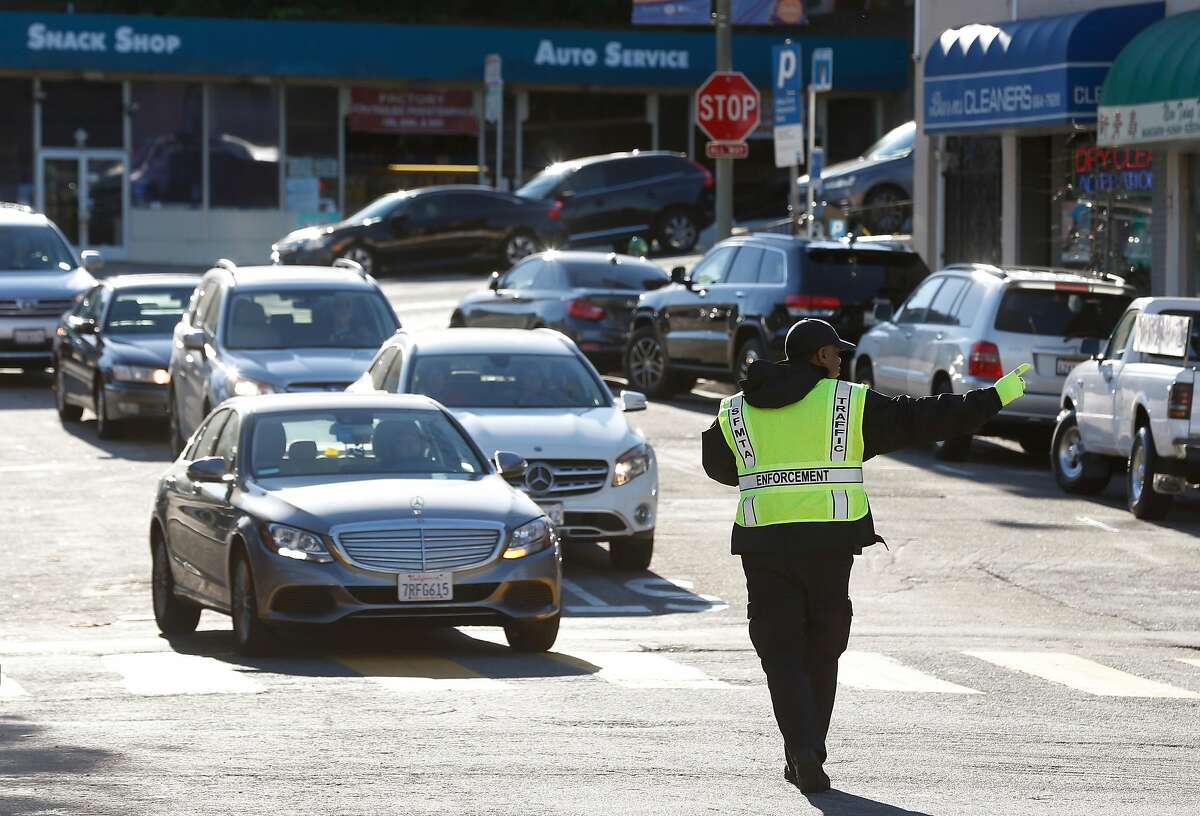 Marcellus Joseph directs traffic in front of the West Portal Muni station in San Francisco, Calif. on Friday, Feb. 22, 2019. Traffic officers have been assigned to the intersection of West Portal Avenue and Ulloa Street for the past few weeks to control the often congested flow of cars, trucks, buses and streetcars.